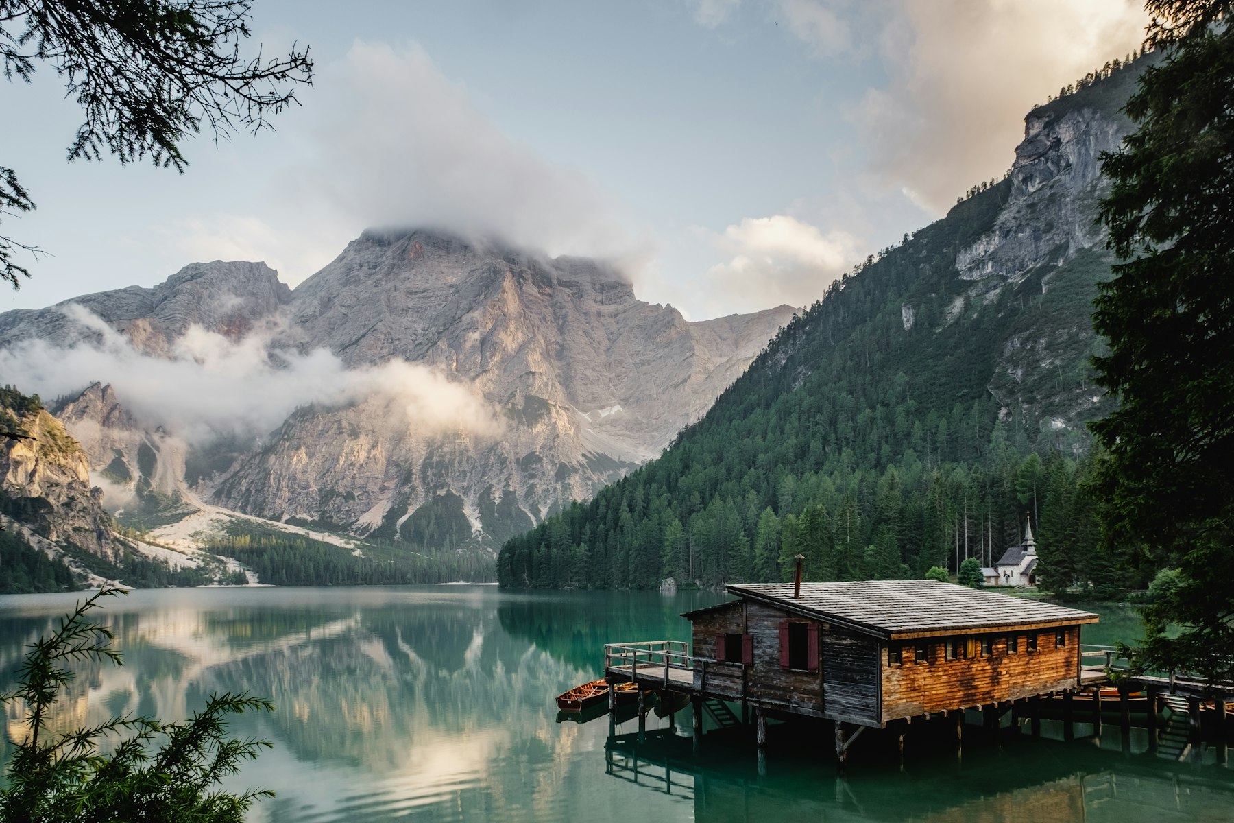 Timber guest house on a still mountain lake at dusk